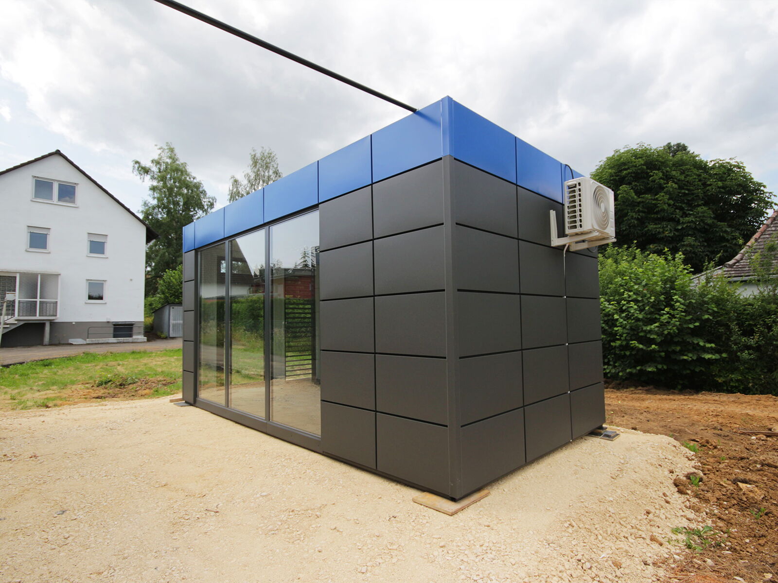 Conteneur de bureau compact avec façade vitrée et climatiseur en extérieur      