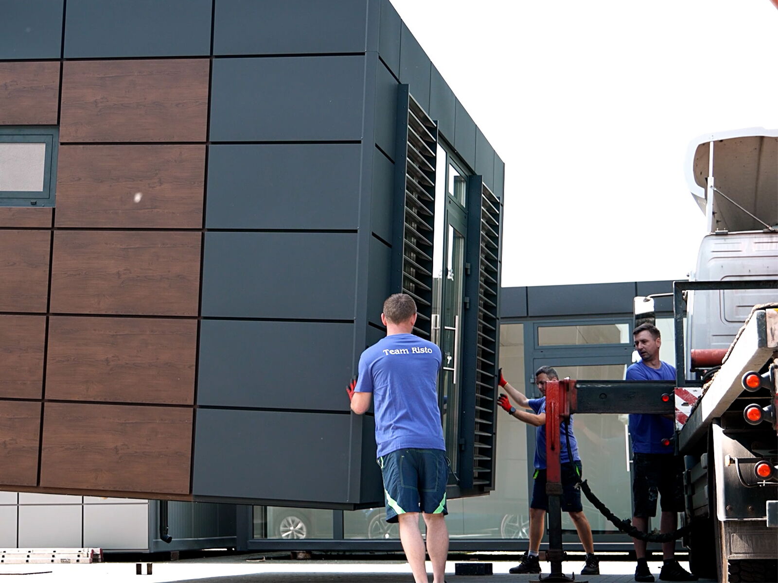 Montage d'un conteneur de bureau avec façade en bois et métal par l'équipe de service      