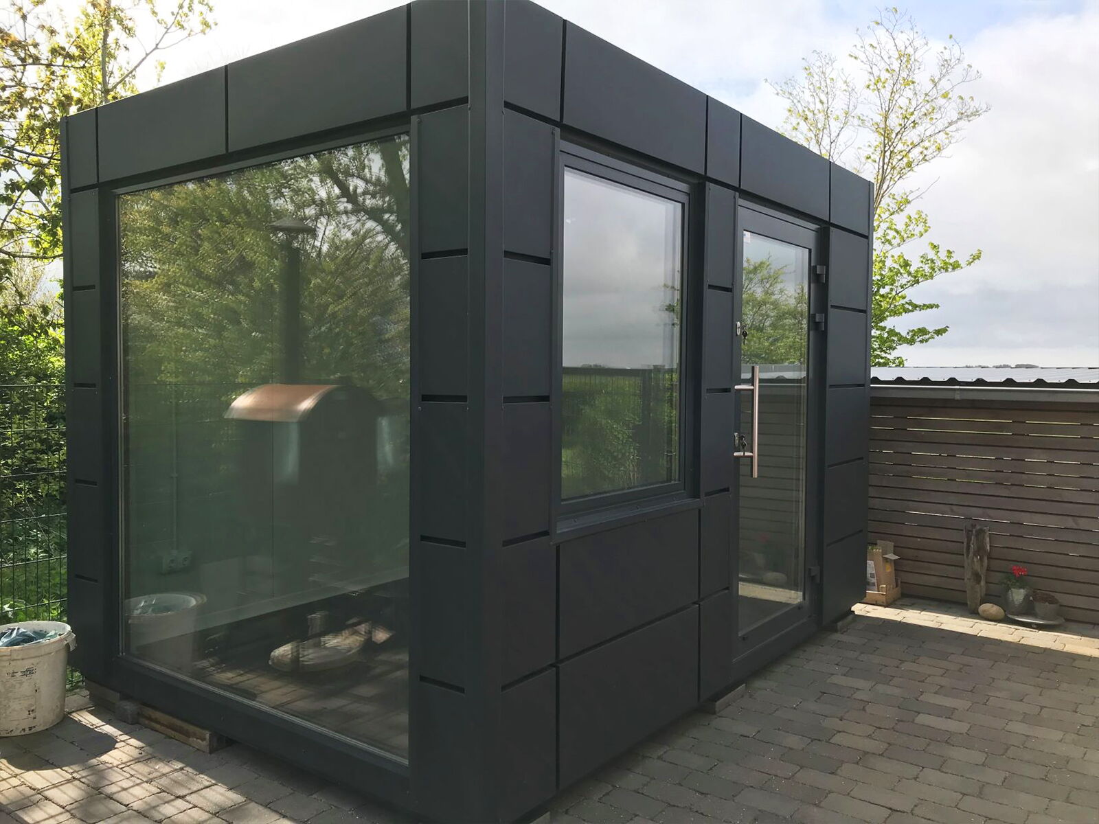 Petit conteneur modulaire design avec grande façade vitrée sur terrasse      